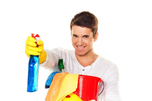 Cleaner using protective gloves and safety footwear during carpet cleaning